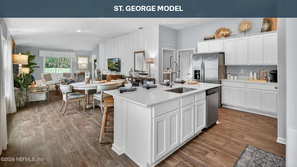a kitchen with stainless steel appliances a dining table chairs and wooden floor