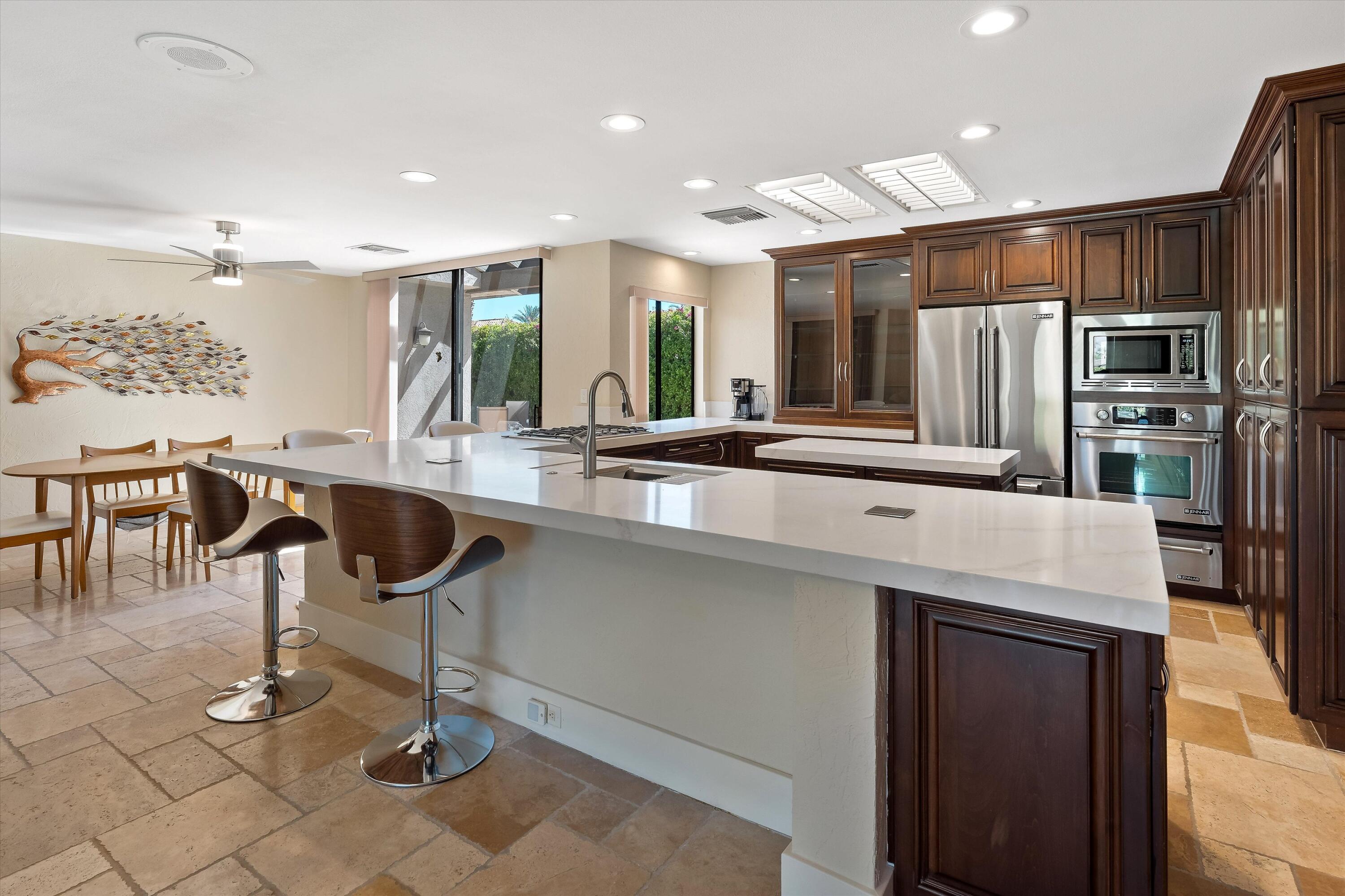 62 Dartmouth Drive Rancho Mirage, CA 92270 - Photo 11 of 46 a kitchen with stainless steel appliances kitchen island granite countertop a sink and a refrigerator