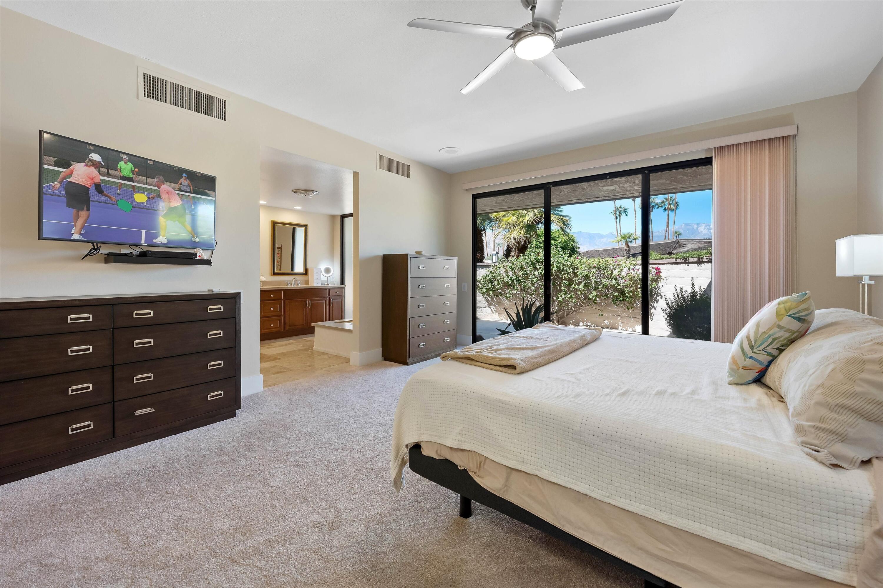 62 Dartmouth Drive Rancho Mirage, CA 92270 - Photo 23 of 46 a bedroom with a bed dresser and a flat tv screen