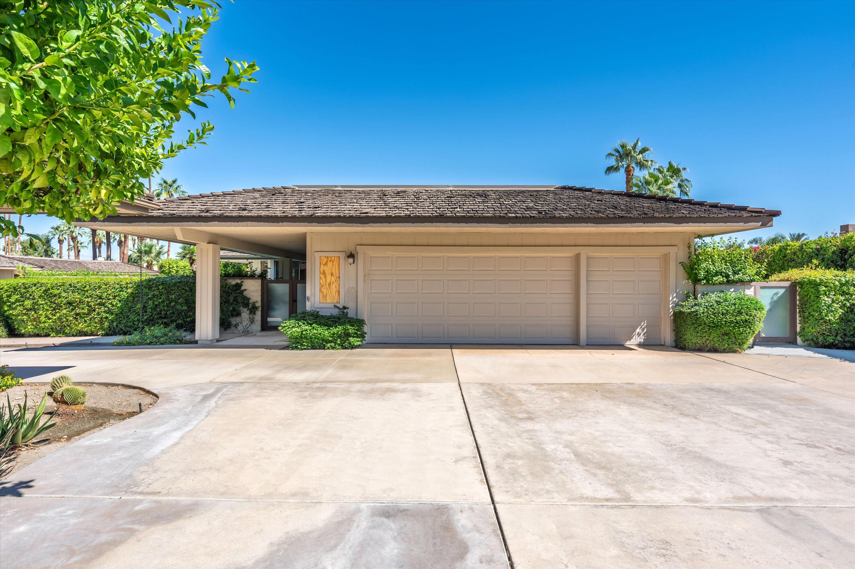 62 Dartmouth Drive Rancho Mirage, CA 92270 - Photo 43 of 46 a front view of a house with a yard and a garage