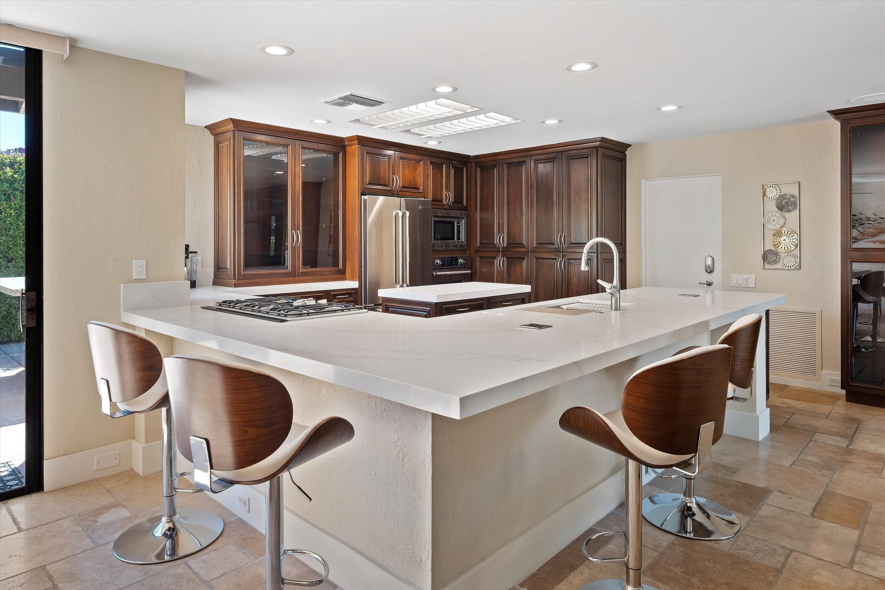 62 Dartmouth Drive Rancho Mirage, CA 92270 - Photo 8 of 46 a kitchen with stainless steel appliances kitchen island a table and chairs