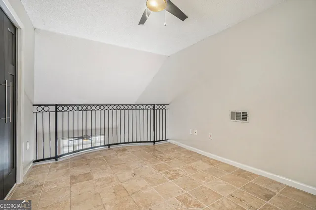 an empty room with a ceiling fan and window