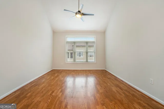 an empty room with a window and wooden floor