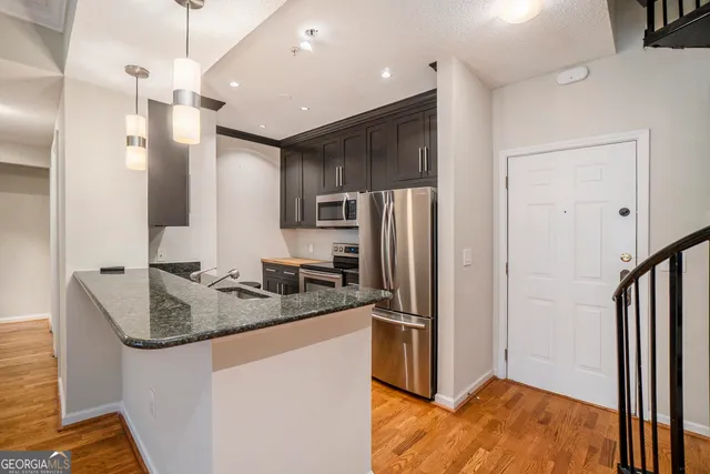 a kitchen with kitchen island a counter top space appliances and a refrigerator