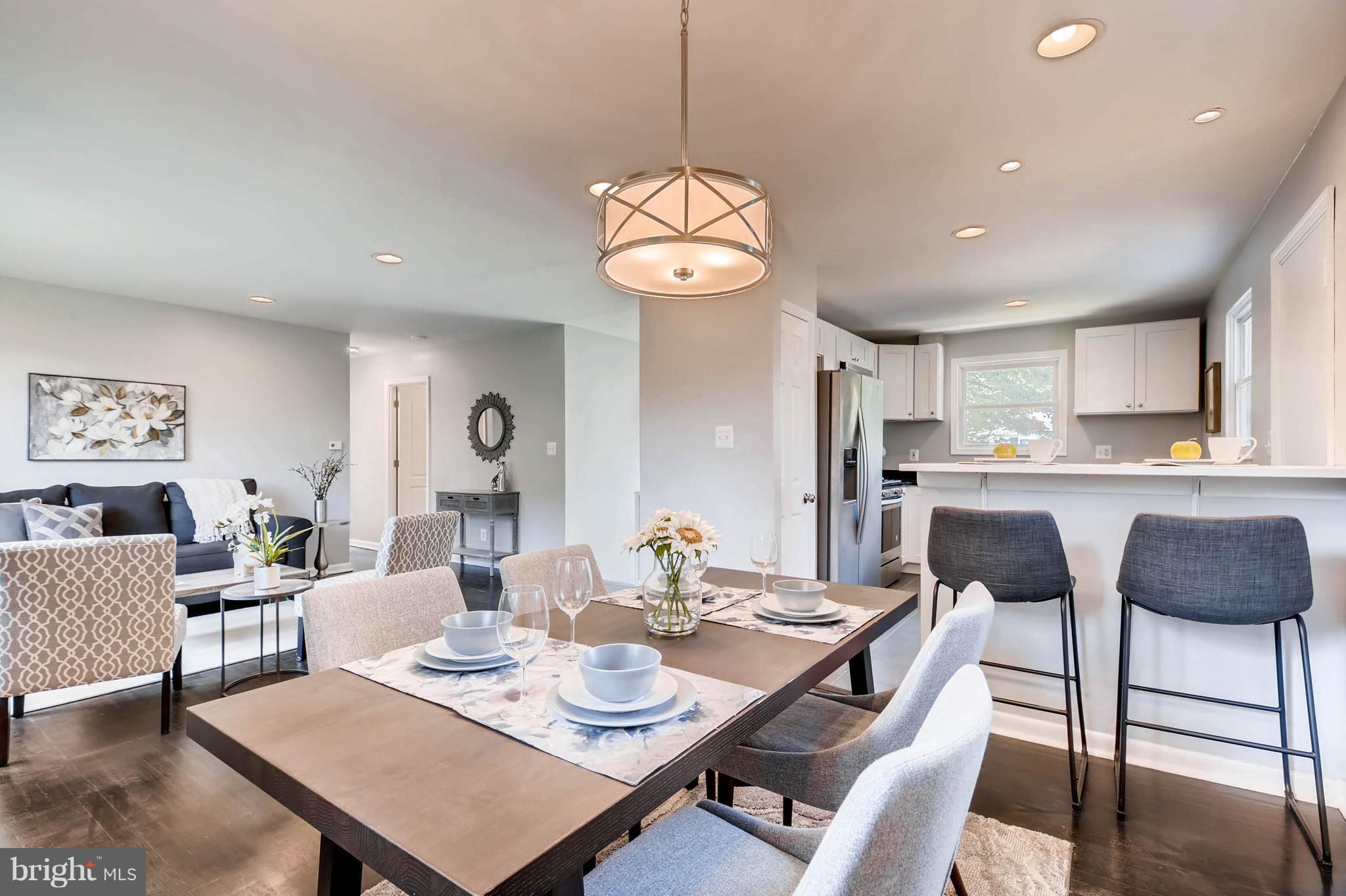 9020 Hamor Road Randallstown, MD 21133 - Photo 1 of 24 a view of a dining room and livingroom with furniture wooden floor and a chandelier