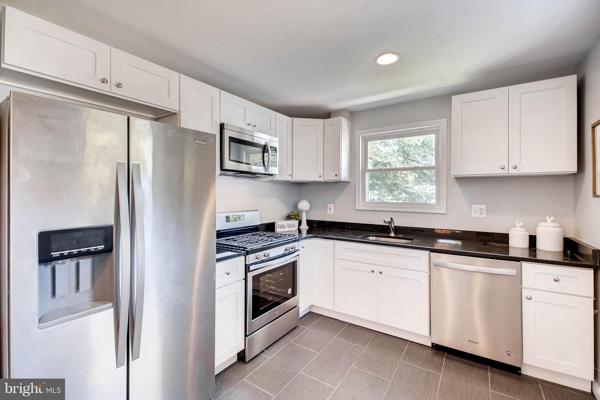 9020 Hamor Road Randallstown, MD 21133 - Photo 8 of 24 a kitchen with granite countertop white cabinets and refrigerator
