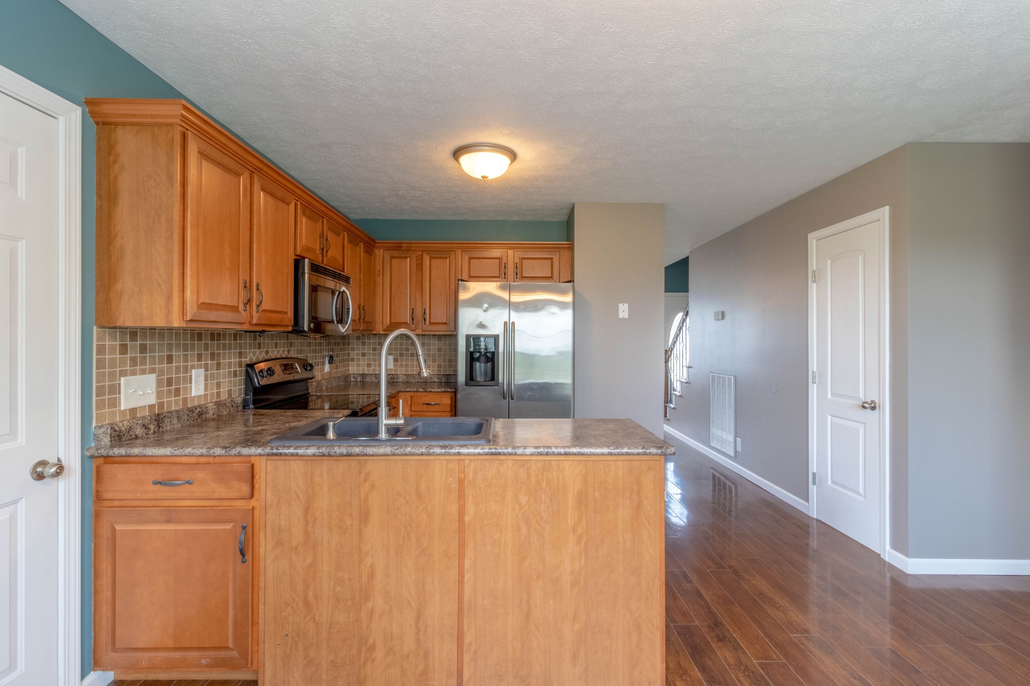 11241 Bell Station Road Oak Grove, KY 42262 - Photo 12 of 33 a kitchen with stainless steel appliances granite countertop a refrigerator a sink dishwasher and wooden cabinets with wooden floor