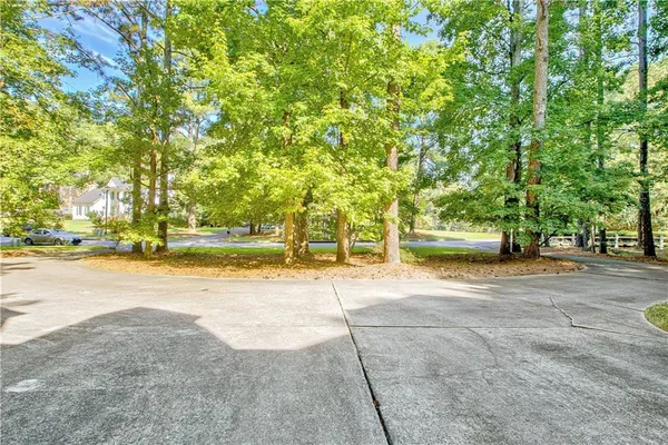 a view of a house with a big yard and large trees