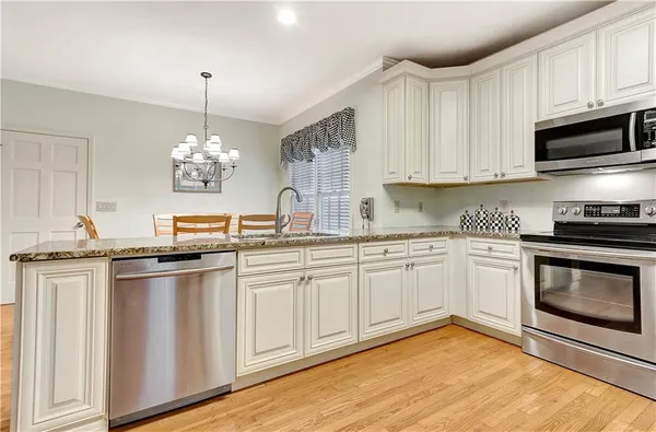 a kitchen with stainless steel appliances granite countertop a stove a sink and a microwave