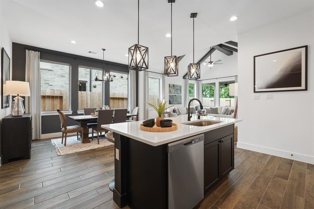 a kitchen with stainless steel appliances granite countertop a sink a stove and a wooden floor