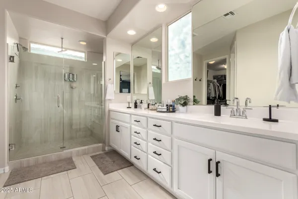 a spacious bathroom with double sink and a mirror