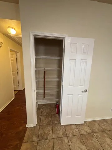 an empty room with wooden floor and cabinet