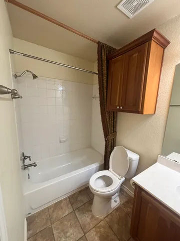a white toilet sitting next to a bath tub