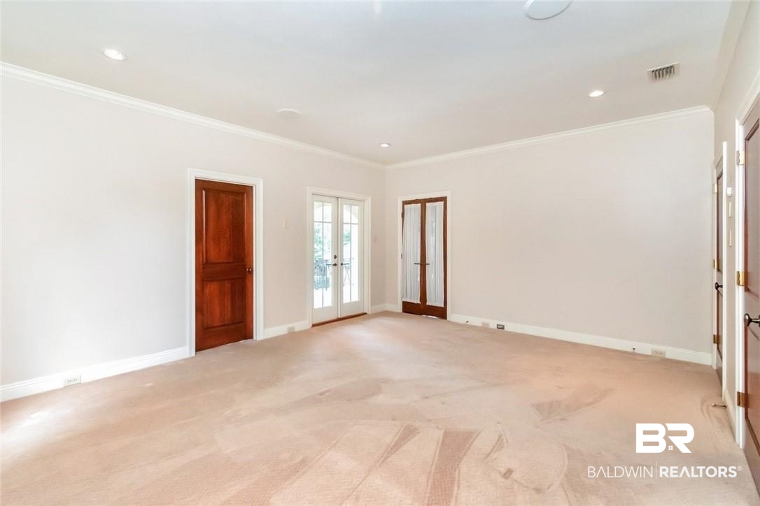 4 Chancery Court Mobile, AL 36608 - Photo 33 of 54 Empty room featuring ornamental molding, light carpet, and french doors