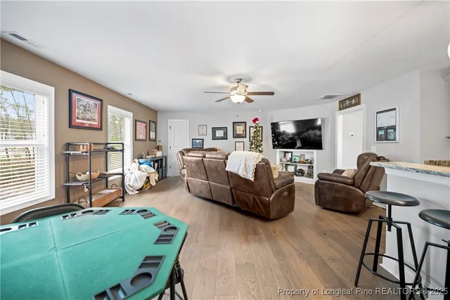 a living room with furniture flat screen tv and large window