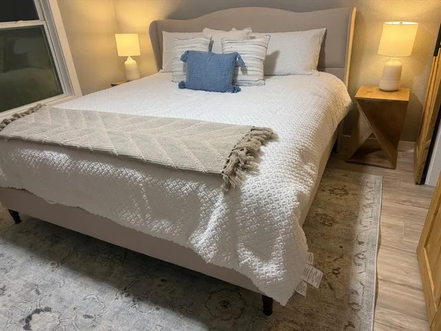 a large bed sitting in a bedroom next to a window