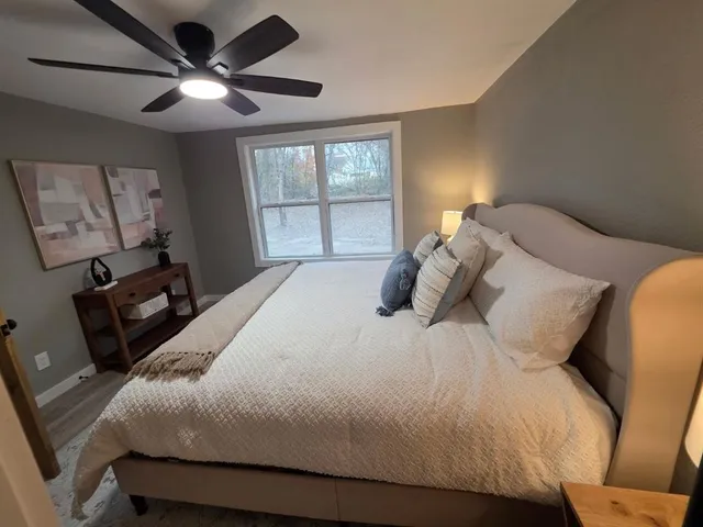 a large bed sitting in a bedroom next to a window