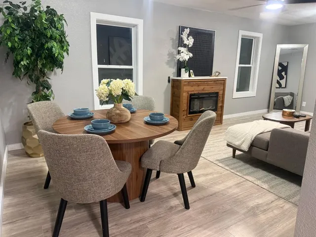 a dining room with furniture potted plants and wooden floor