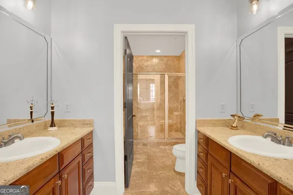 a en suite bathroom with a granite countertop sink and a mirror