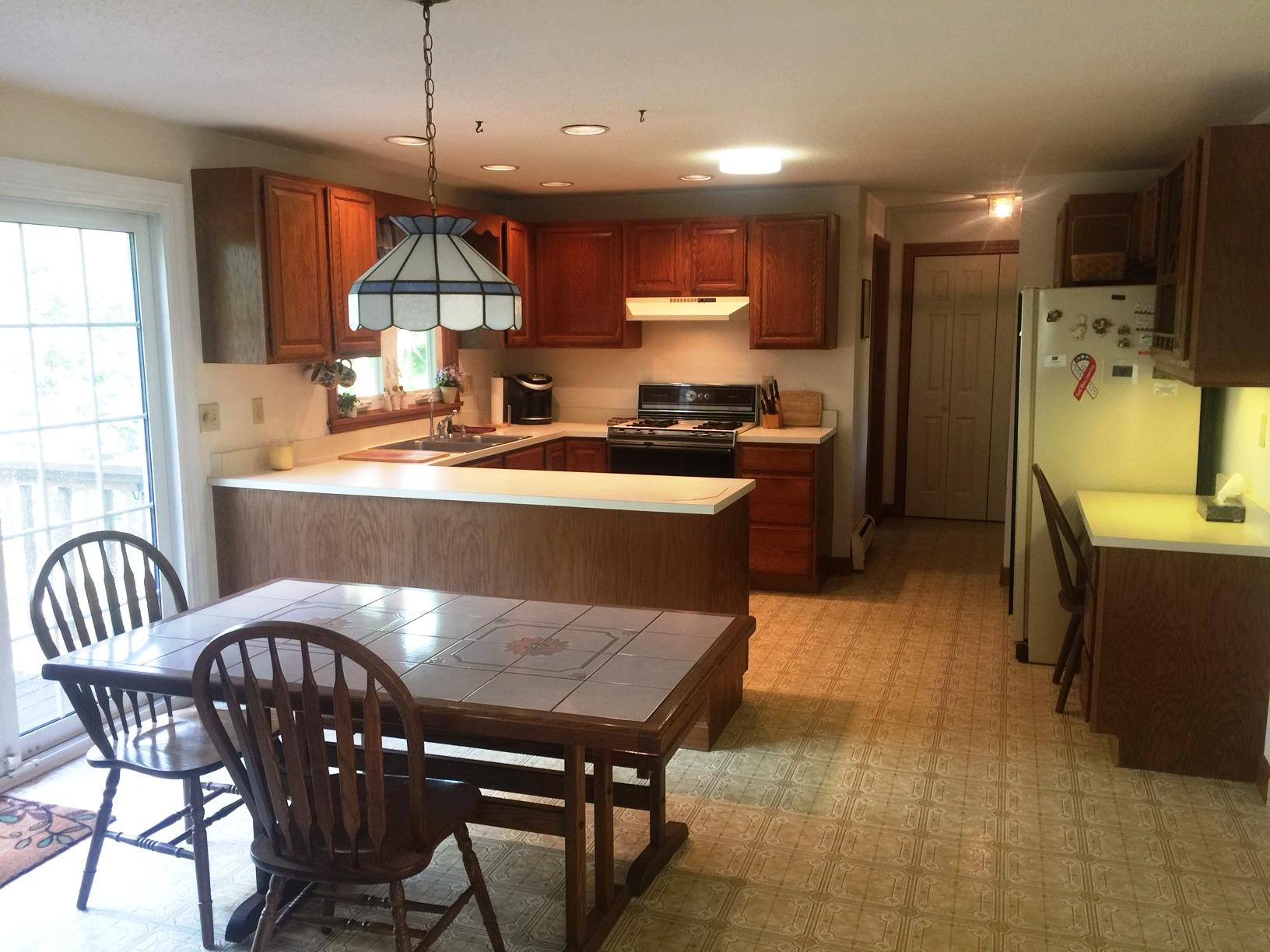 17 Braeside Road Falmouth, MA 02540 - Photo 4 of 17 a kitchen with stainless steel appliances granite countertop a table chairs refrigerator sink and cabinets