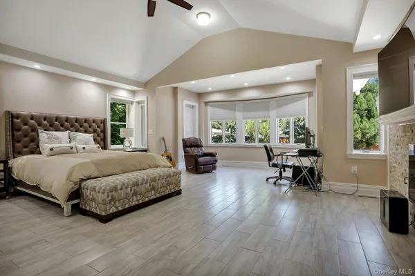 a spacious bedroom with a bed a table and a potted plant