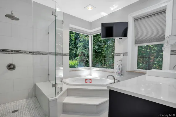 a bathroom with a tub sink and mirror