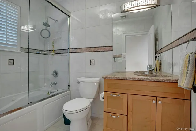a bathroom with a granite countertop toilet sink and shower