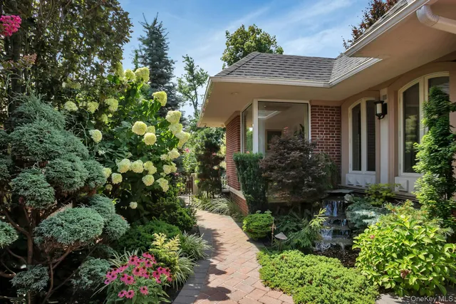 a front view of a house with a tree