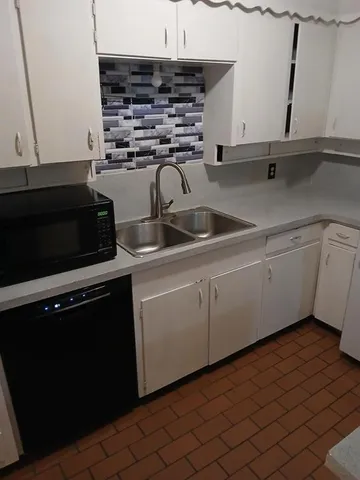 a kitchen with stainless steel appliances a sink dishwasher stove and cabinets