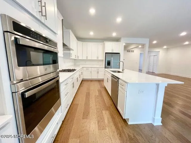 a kitchen with stainless steel appliances kitchen island granite countertop a stove a sink and a microwave