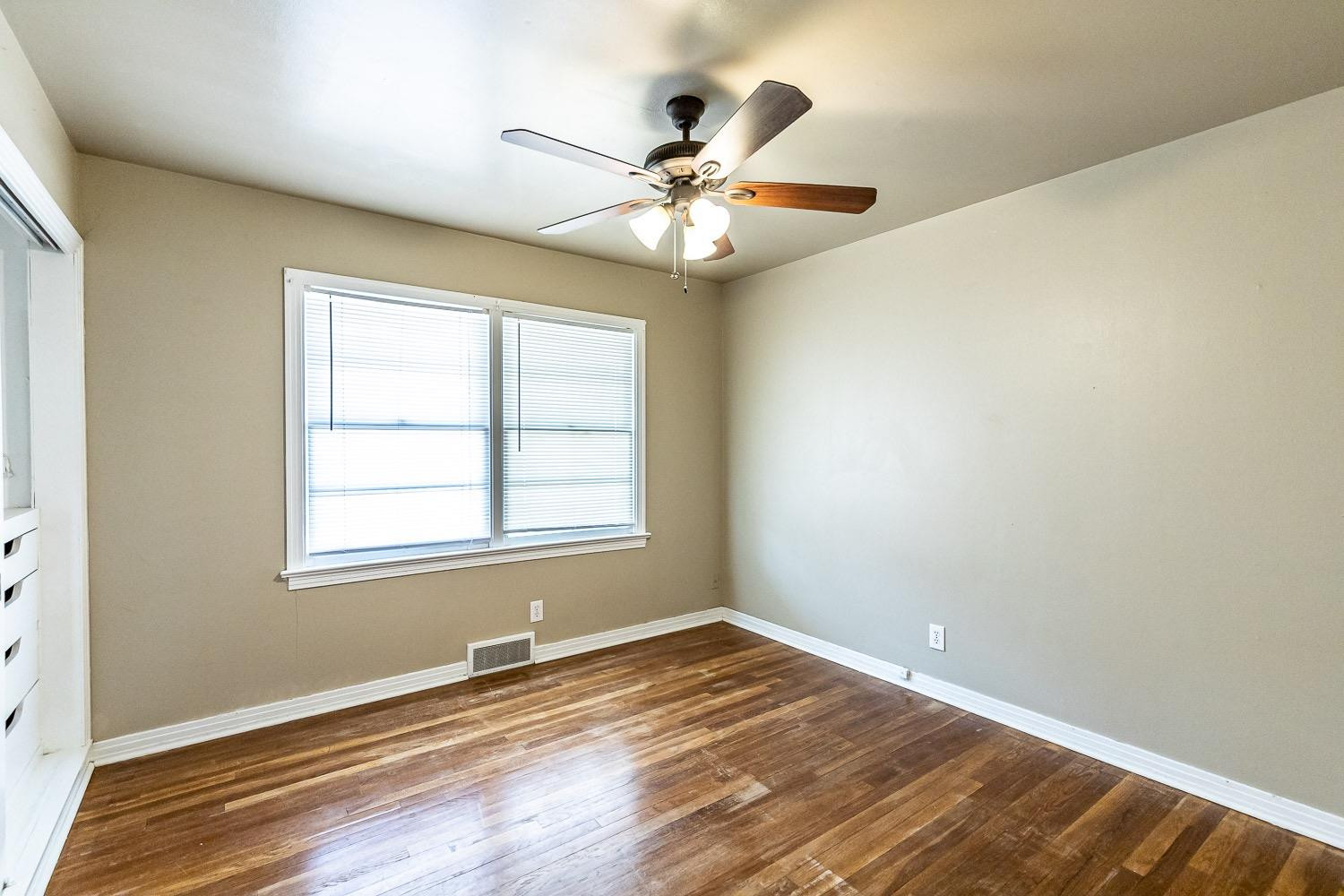 3708 27th Street Lubbock, TX 79410 - Photo 22 of 23 an empty room with wooden floor fan and windows
