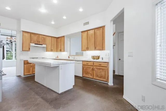 a kitchen with a white stove cabinets and a window