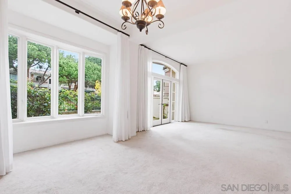 5226 Renaissance Avenue San Diego, CA 92122 - Photo 12 of 41 a view of a big room with windows and chandelier fan