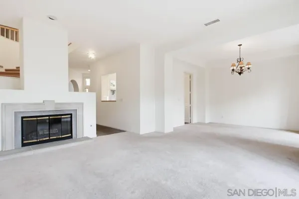 an empty room with fan and fireplace