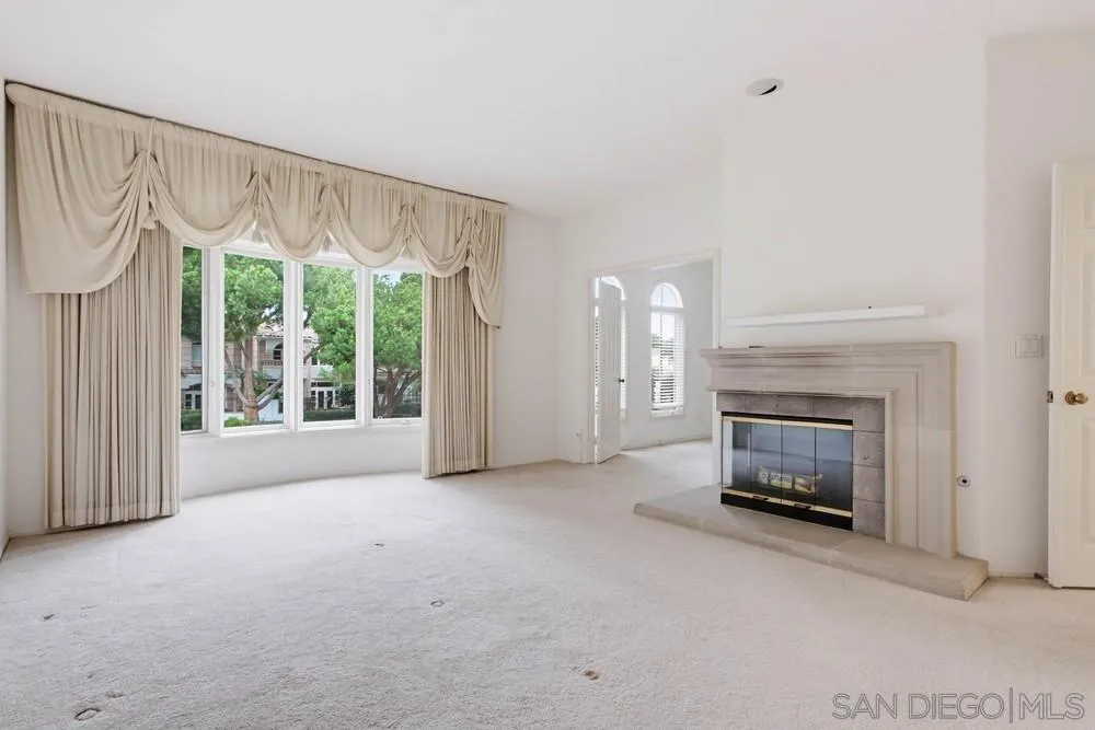 5226 Renaissance Avenue San Diego, CA 92122 - Photo 19 of 41 a view of an empty room with a fireplace and a window