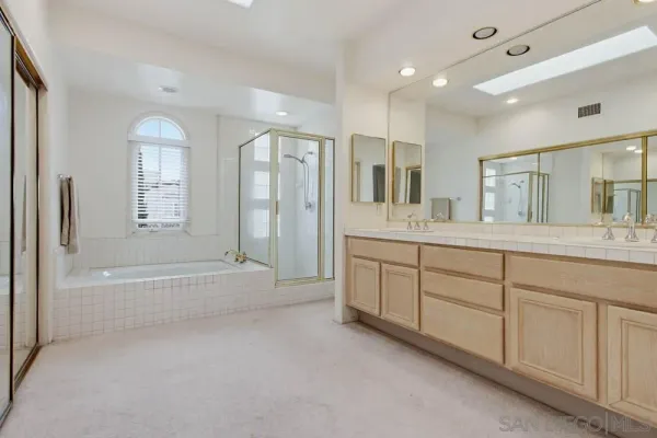 a spacious bathroom with a mirror a double vanity sink and a bathtub