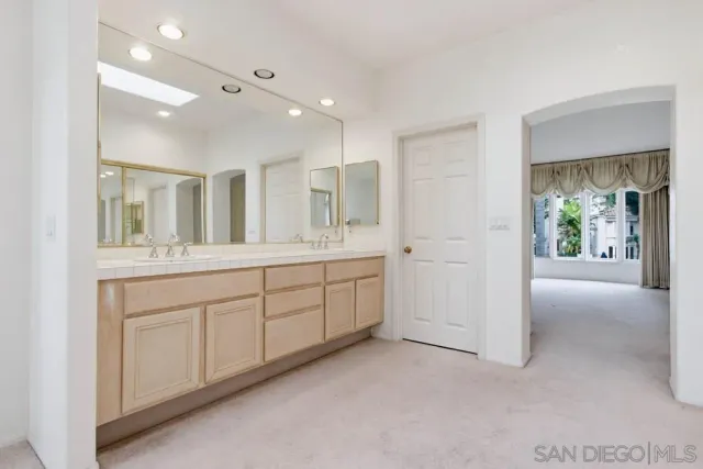 a spacious bathroom with a double vanity sink and a mirror