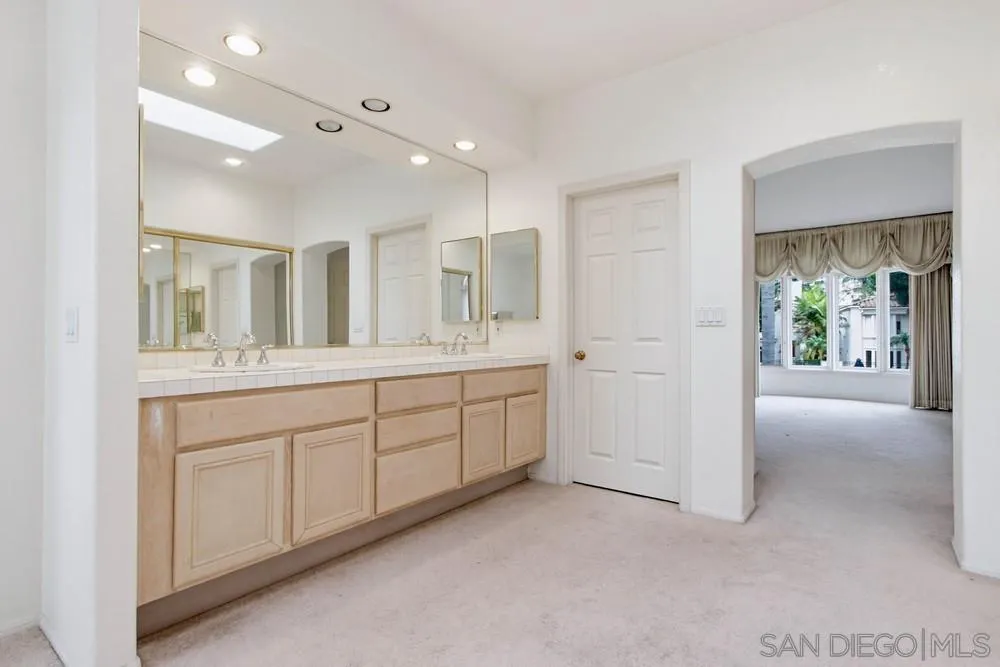 5226 Renaissance Avenue San Diego, CA 92122 - Photo 26 of 41 a spacious bathroom with a double vanity sink and a mirror
