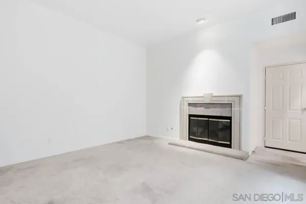 a view of empty room with a fireplace