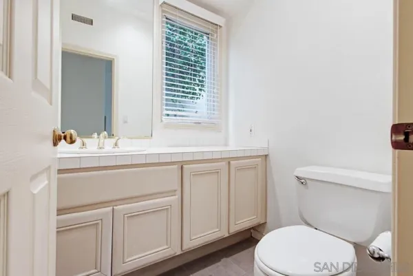 a bathroom with a sink vanity mirror and toilet