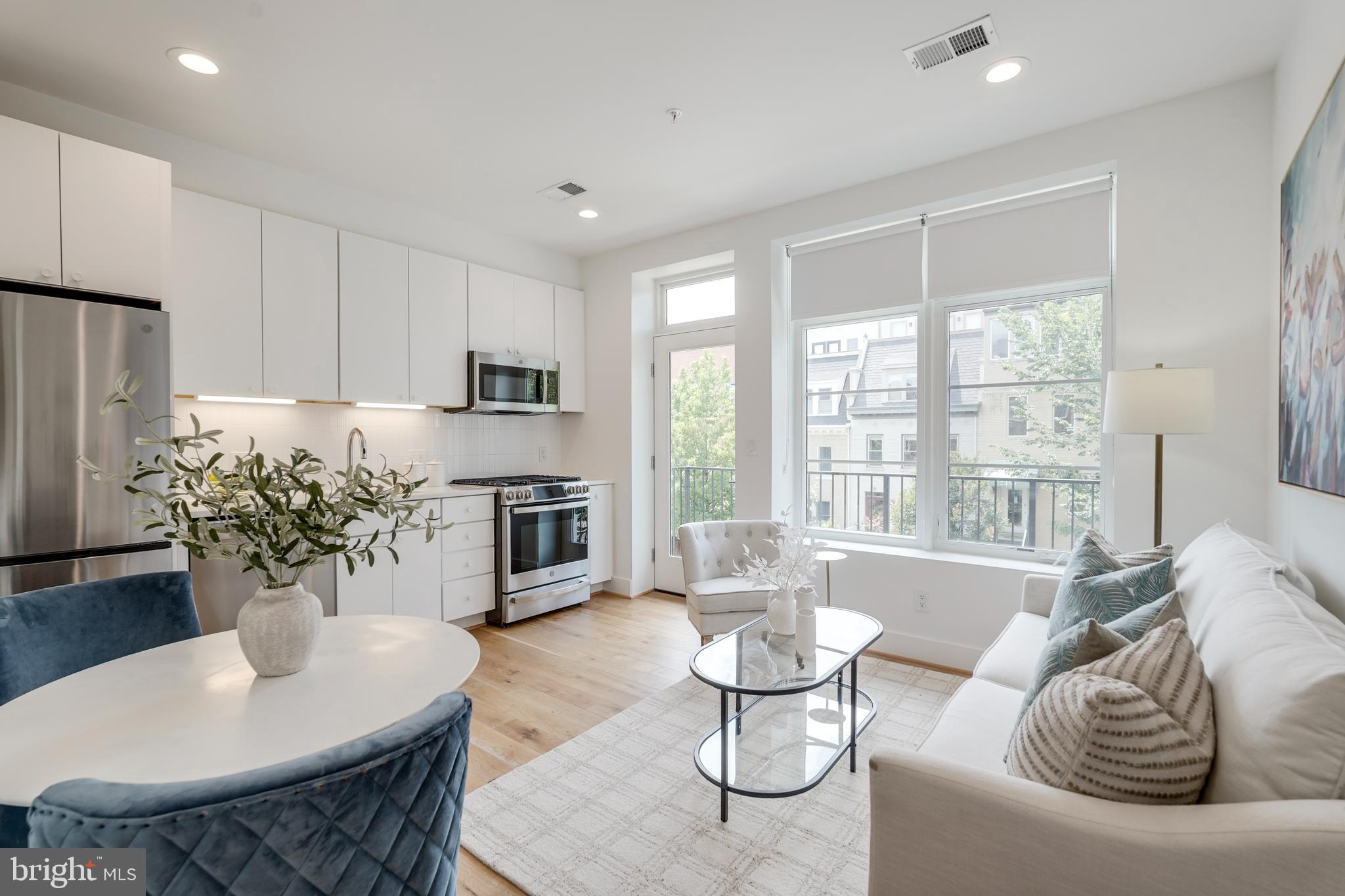 a living room with furniture potted plant and a large window