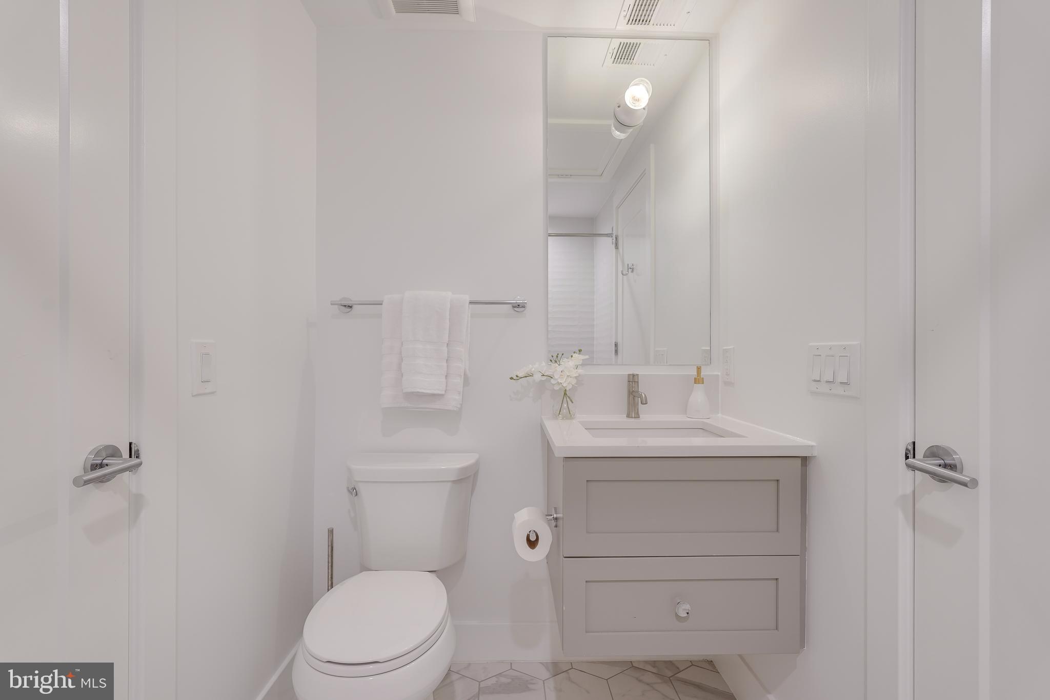 2419 Ontario Road Northwest, Unit 202 Washington, DC 20009 - Photo 14 of 15 a bathroom with a toilet a sink a mirror and vanity