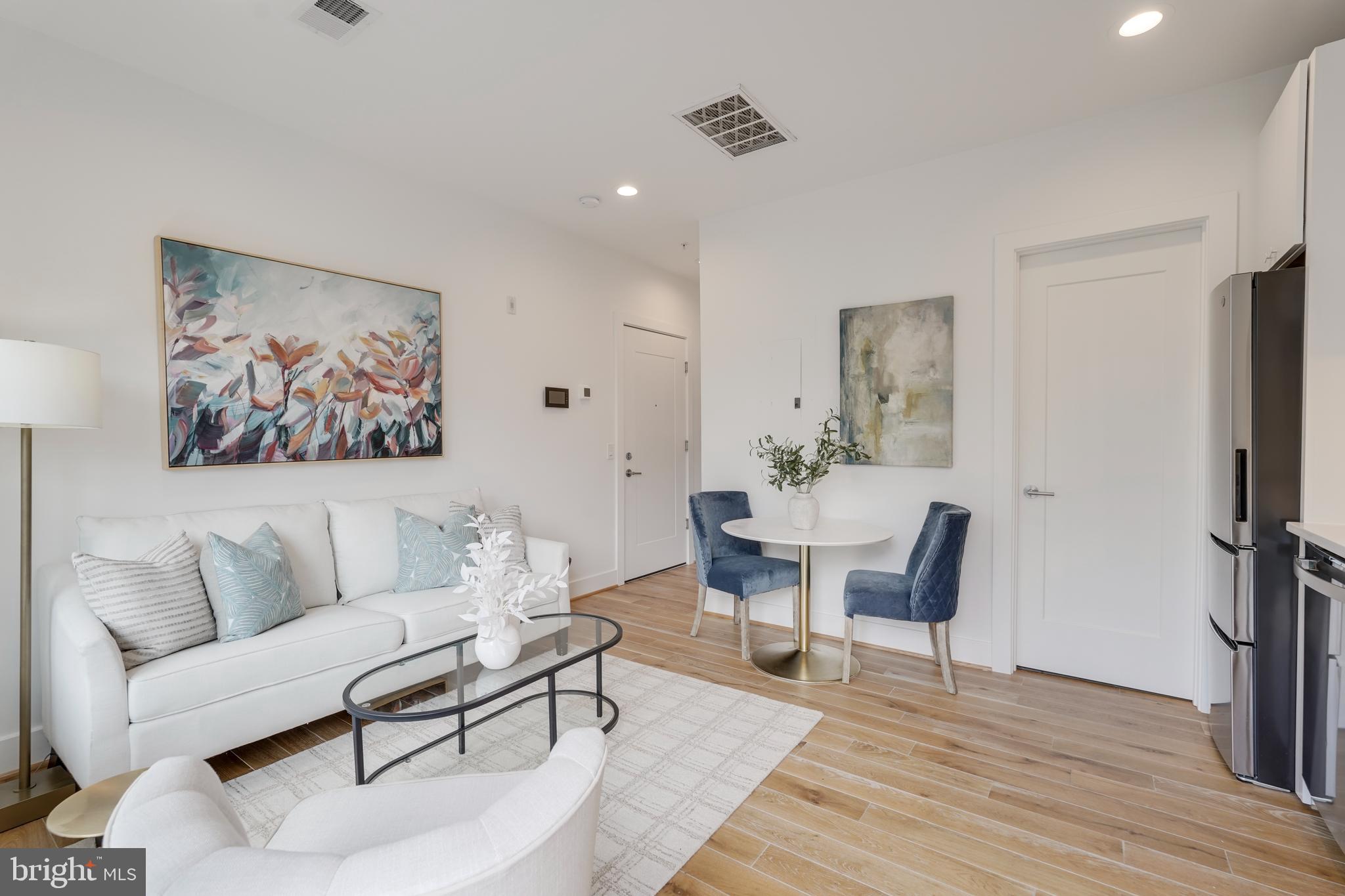 2419 Ontario Road Northwest, Unit 202 Washington, DC 20009 - Photo 3 of 15 a living room with furniture a flat screen tv and a table