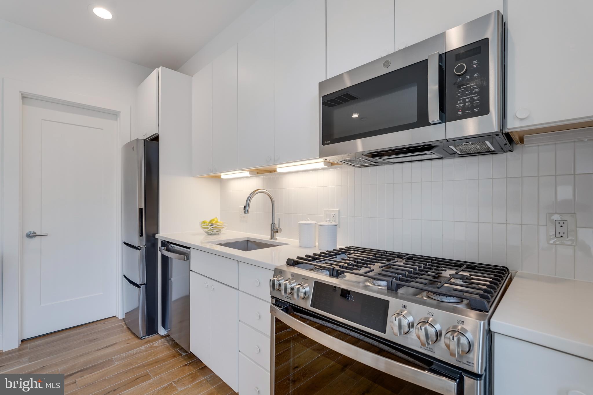 2419 Ontario Road Northwest, Unit 202 Washington, DC 20009 - Photo 5 of 15 a stove top oven sitting inside of a kitchen