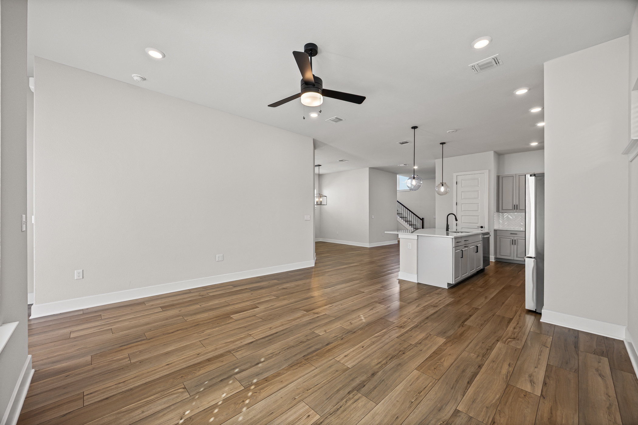 5806 Rangeland Road Austin, TX 78747 - Photo 15 of 34 Rich hardwood flooring flows through this contemporary living area into an open-concept kitchen.