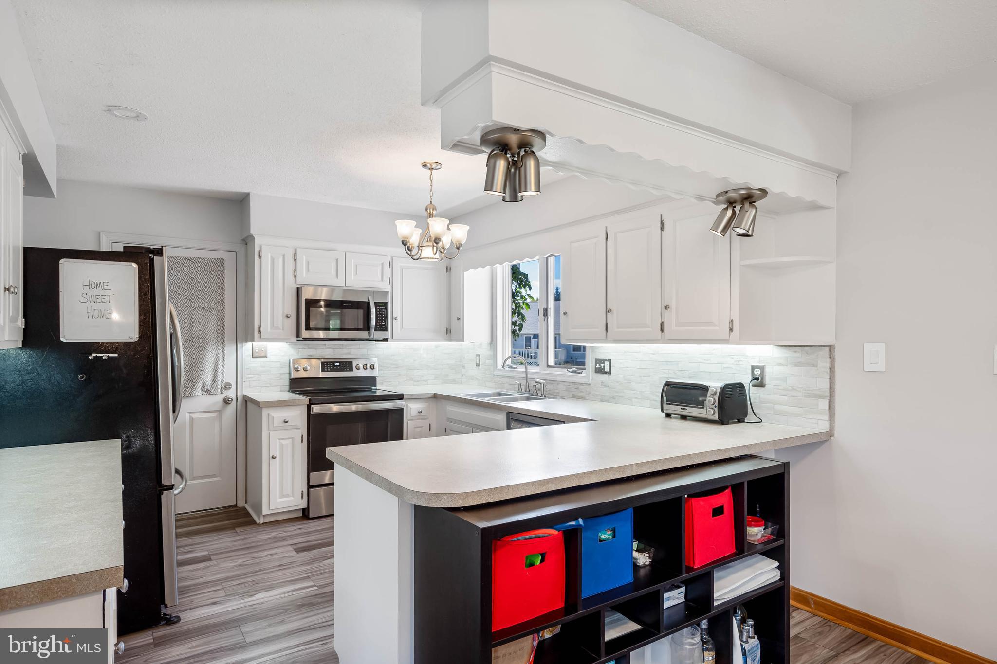 521 Harbor Road Ocean View, DE 19970 - Photo 2 of 46 a kitchen with a sink a stove and chairs