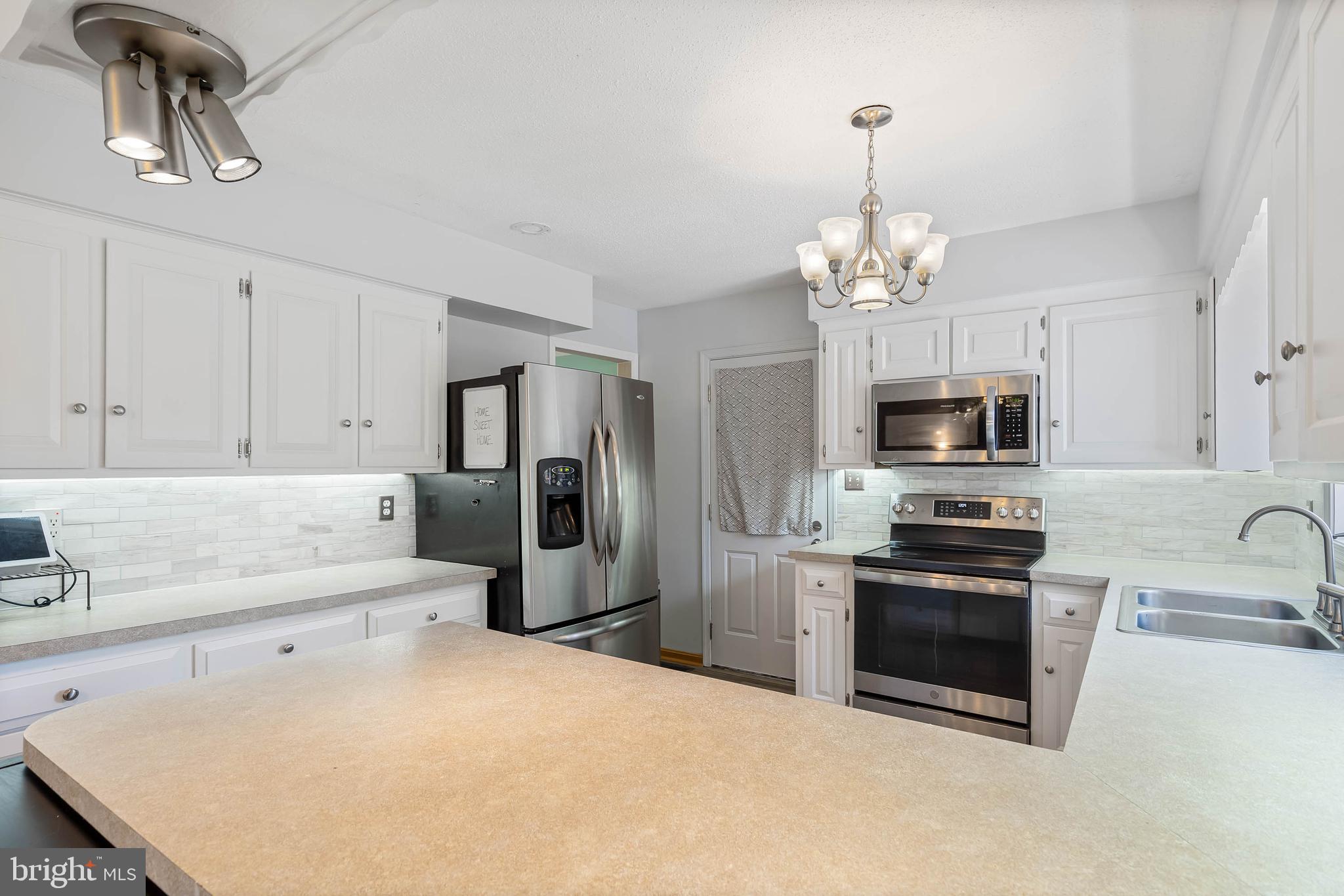 521 Harbor Road Ocean View, DE 19970 - Photo 4 of 46 a kitchen with stainless steel appliances a refrigerator sink and microwave