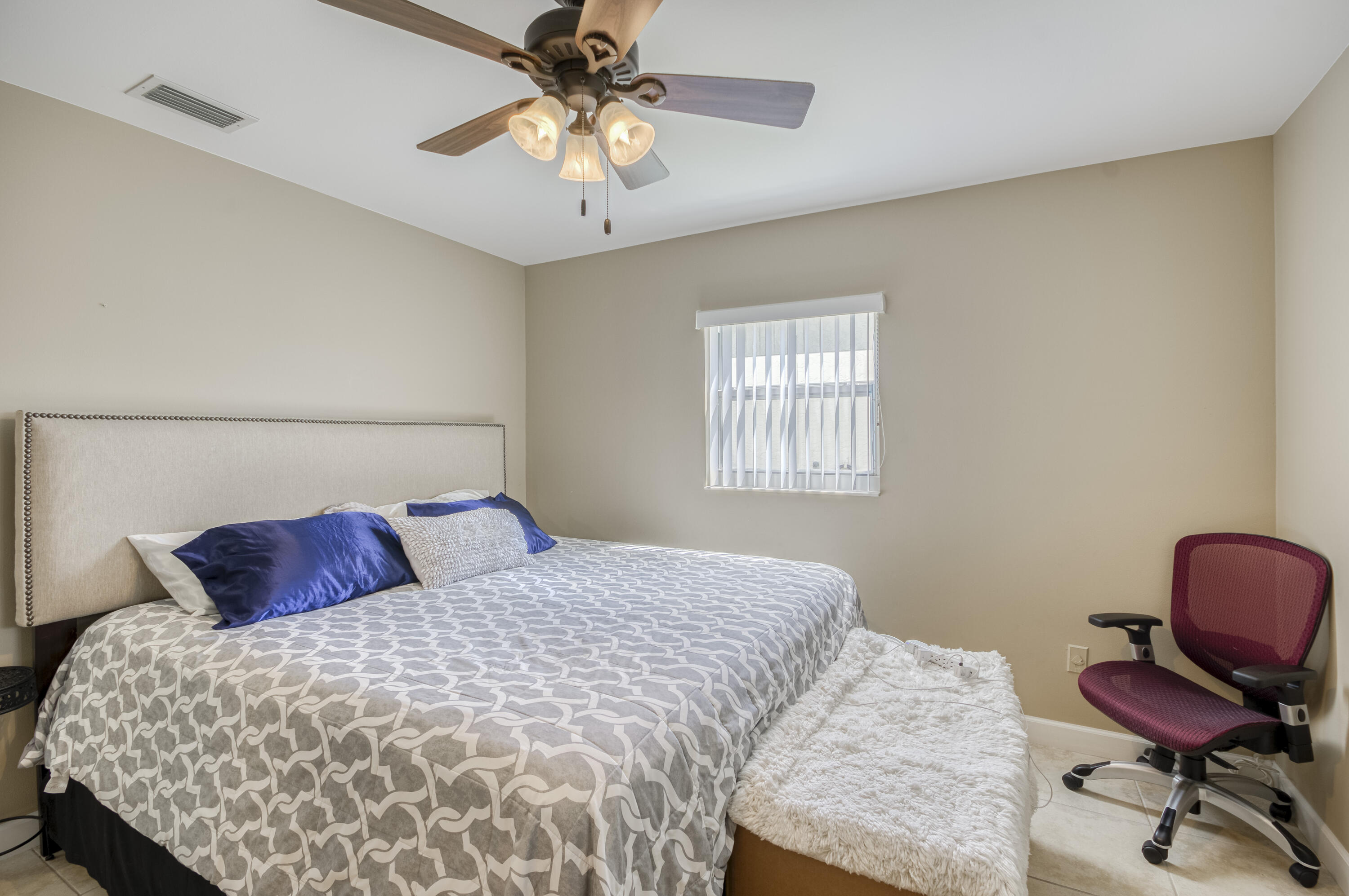 5398 Belleville Road West Palm Beach, FL 33417 - Photo 12 of 25 a bedroom with a bed a chair and a chandelier