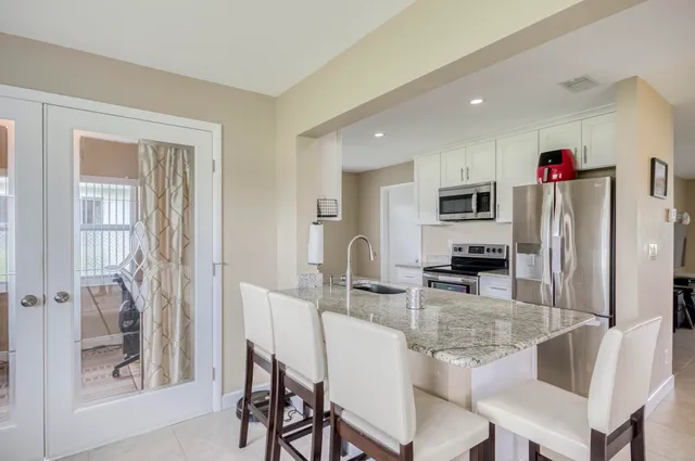 a kitchen with stainless steel appliances granite countertop a refrigerator and microwave