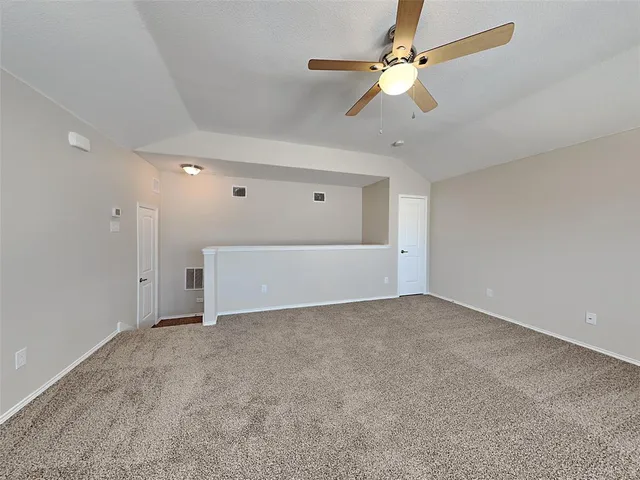 a view of an empty room with a ceiling fan